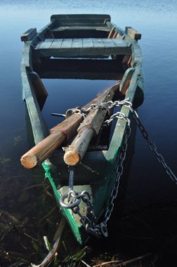 Kürek teknesi kıyıya demirlemiş. Nehirde bahar. Yüzen.