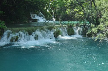 Yüksek şelale, gölün içine kayaların üzerinden akan su. Milli Park Plitvice Gölleri. Hırvatistan'da turizm.