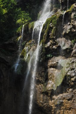 Yüksek şelale, gölün içine kayaların üzerinden akan su. Milli Park Plitvice Gölleri. Hırvatistan'da turizm.