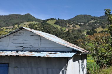 Kosta Rika 'daki Irazu volkanının tarım yamaçlarında verimli topraklar ve güneşli yamaçlarda sayısız mahsul var. Vadi volkanik koninin altında asılı bulutlarla çevrilidir..