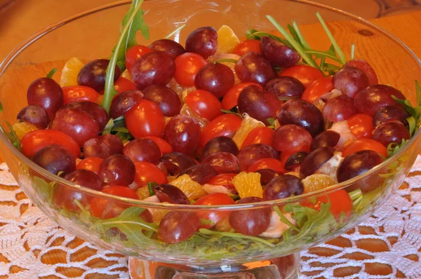 Salad in a glass dish. Rocket salad with grapes.