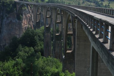 Karadağ 'daki Tara Nehri üzerindeki köprü ve kanyonun iki kıyısını birbirine bağlayan köprü. Temiz bir nehrin taştan yatağı vadinin içinden bir dağ yamacında yol boyunca akıyor..