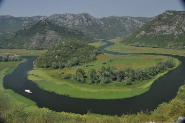 Karadağ 'daki Skadar Gölü' nün bir parçası olan Crnojevia Nehri. Nehrin güzel kıvrımları tepelerin arasından akan teknelerle turist gezileri..