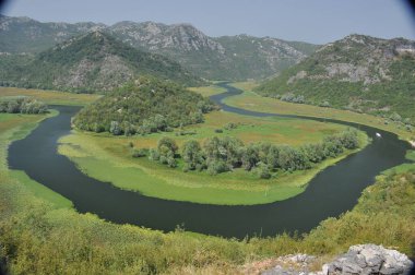 Karadağ 'daki Skadar Gölü' nün bir parçası olan Crnojevia Nehri. Nehrin güzel kıvrımları tepelerin arasından akan teknelerle turist gezileri..