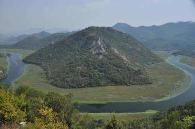 Karadağ 'daki Skadar Gölü' nün bir parçası olan Crnojevia Nehri. Nehrin güzel kıvrımları tepelerin arasından akan teknelerle turist gezileri..