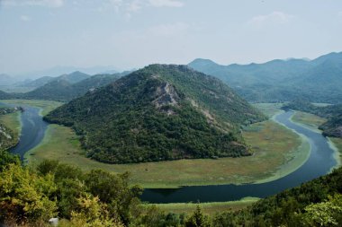 Karadağ 'daki Skadar Gölü' nün bir parçası olan Crnojevia Nehri. Nehrin güzel kıvrımları tepelerin arasından akan teknelerle turist gezileri..
