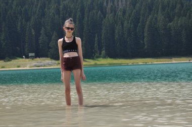Çocuklar, suda oynayan kardeşlerim. Zabljak yakınlarındaki Durmitor dağlarında kara göl. Karadağ 'da güzel bir yer
