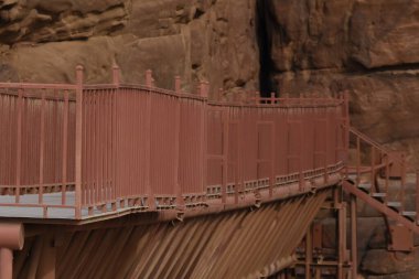 Ürdün 'deki Wadi Mujib Kanyonu' na giriş. Dik kayalar ve oyulmuş hızlı akan bir nehir. Su yolu üzerinde turistler için geçiş ve cazibe zorluğu.