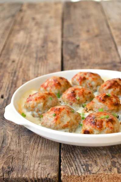 Meatballs in a white sauce. Food Photography. Wooden background.