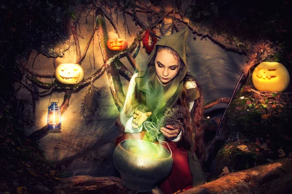 Bruxa fabrica poções em sua caverna . — Fotografia de Stock