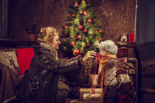 Mor och son dekorera en julgran. — Stockfoto