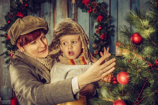 Moeder en zoon versieren van een kerstboom. — Stockfoto