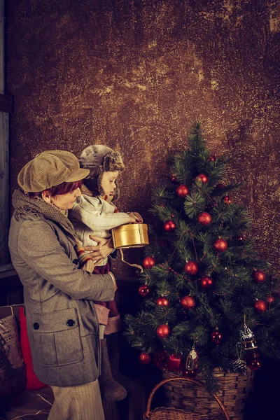 Moeder en zoon versieren van een kerstboom. — Stockfoto