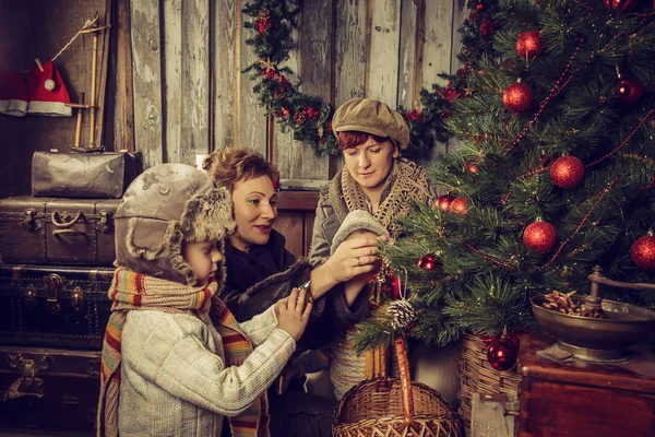 Madres con niños decoran el árbol de Navidad . —  Fotos de Stock