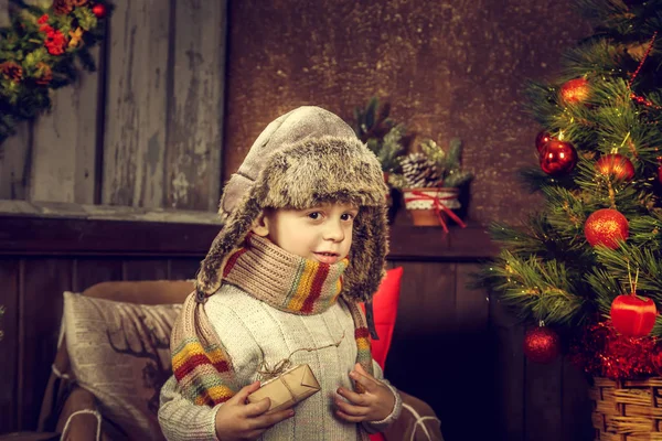 Liten rolig pojke nära en julgran. — Stockfoto