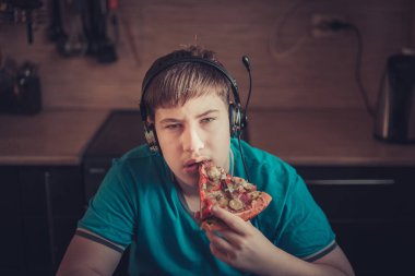 Genç bir laptop oturan pizza yemek.