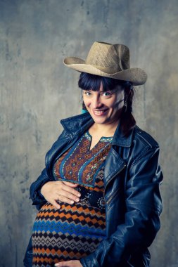 Taş duvar arka plan üzerinde hamile kadın.