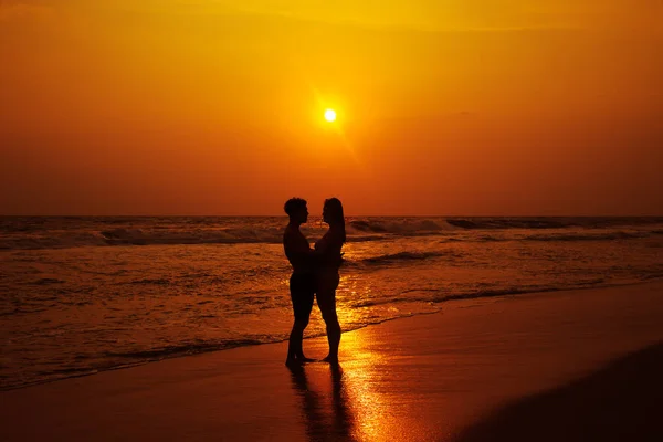 Silhouetten eines liebenden Paares an der Küste des Ozeans. — Stockfoto