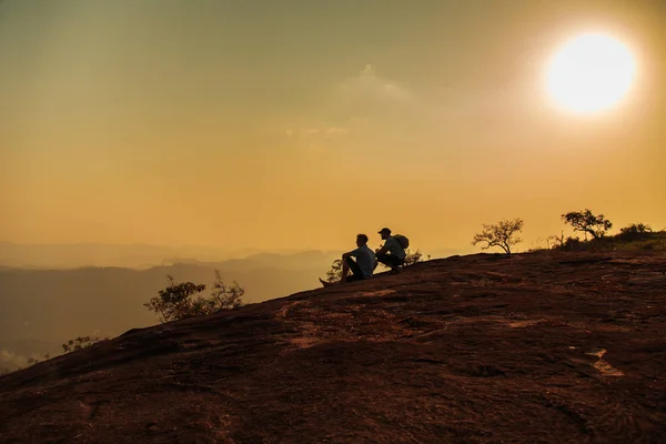 Turistas observando la puesta de sol en la cima de la montaña . —  Fotos de Stock