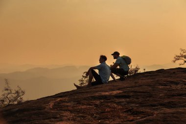 Dağın tepesinde gün batımını izlemek turist.