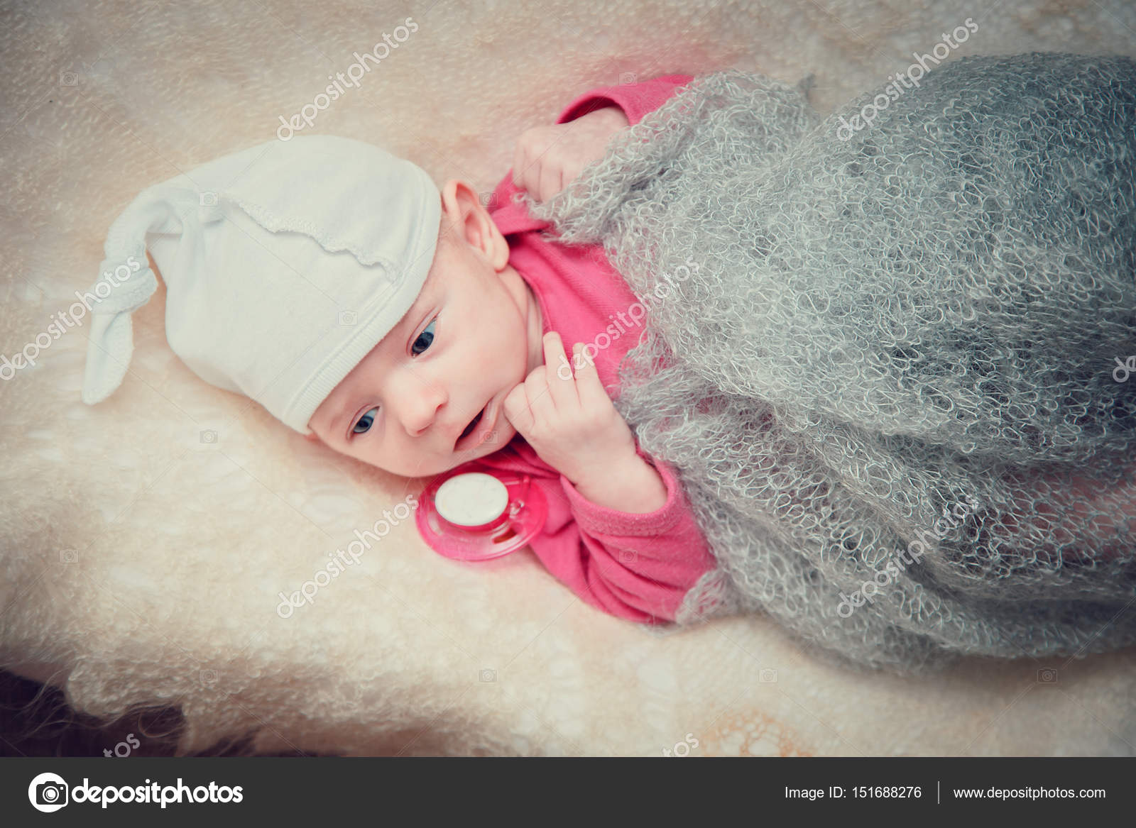 La niña de 3 meses está acostada en la cama. bebé con un vestido rosa y una  diadema en un pañal