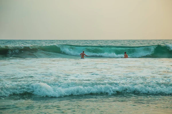 Dos hombres se sumergen en las olas . — Foto de Stock