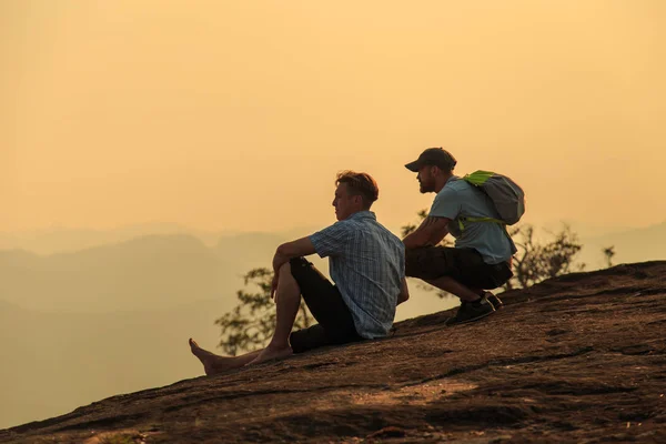 Turistas observando la puesta de sol en la cima de la montaña . —  Fotos de Stock