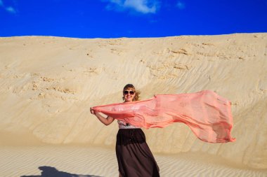 Çölde pembe bir bezle güzel sarışın. 