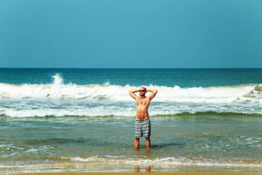 Sahilde oturan adam. 