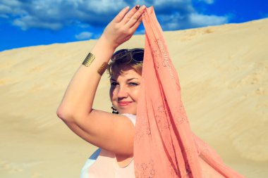 Çölde pembe bir bezle güzel sarışın. 