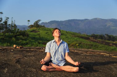 Adam fiziksel egzersizler dağlar arasında çalışmaktadır.
