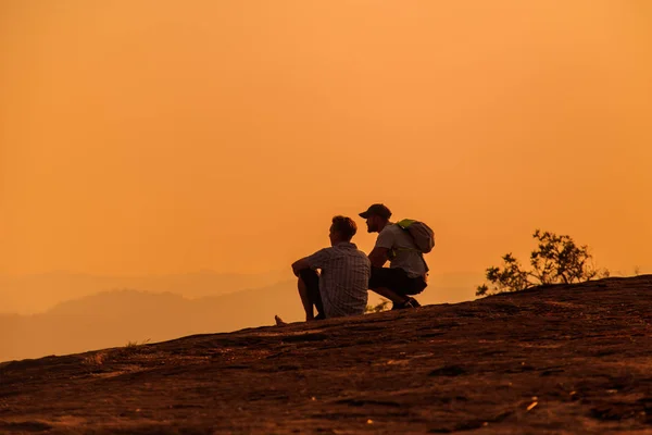 Touristen beobachten den Sonnenuntergang auf dem Gipfel des Berges. — Stockfoto