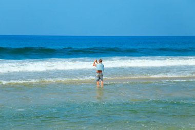 Adam sahilde resimler alıyor.