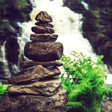 Taş piramit yakınındaki bir tropik şelale. 