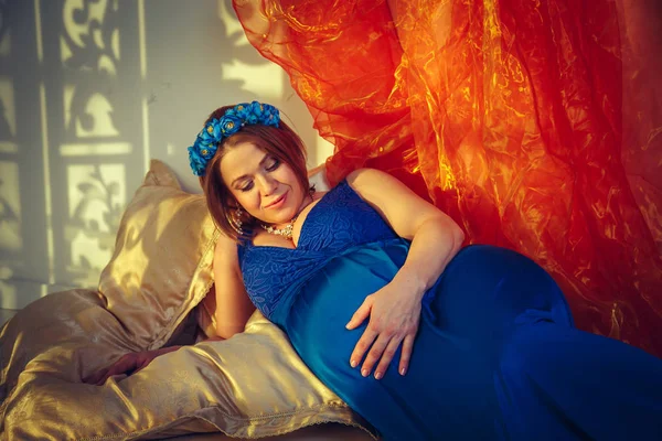 Mooie gelukkig zwangere vrouw in een blauwe jurk. — Stockfoto