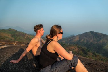 Dağın tepesinde gün batımını izlemek turist.