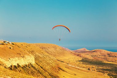 bir vadi üzerinde uçan Yamaçparaşütü.