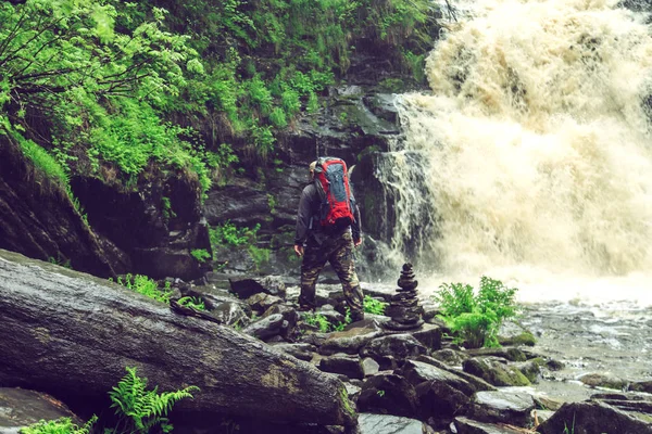 Senderista con una mochila cerca de la cascada . —  Fotos de Stock