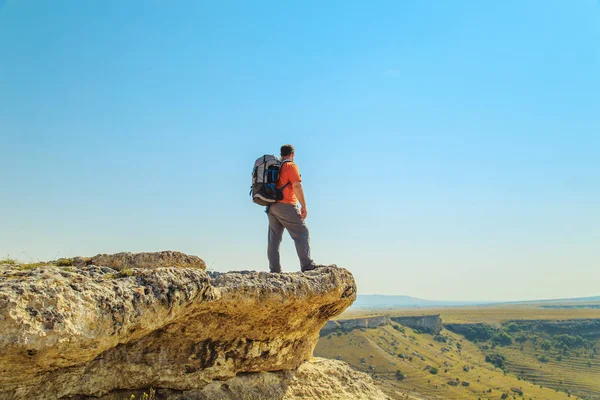 Turista con una mochila en la cima de la montaña . —  Fotos de Stock