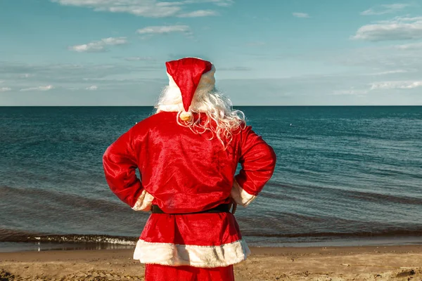 Santa Claus is standing on the beach. Stock Photo