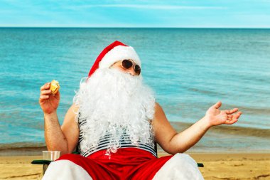 Noel Baba sahilde bir hamburger yemek. 