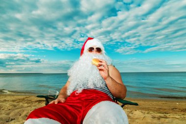 Noel Baba sahilde bir hamburger yemek. 