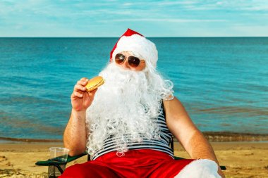 Noel Baba sahilde bir hamburger yemek. 