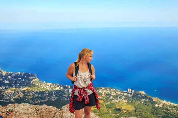 Девушка с рюкзаком на вершине горы . — стоковое фото