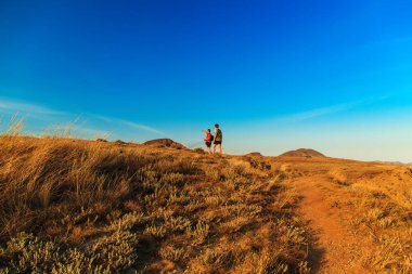 Tepeler arasında iki turist yürüyüş.