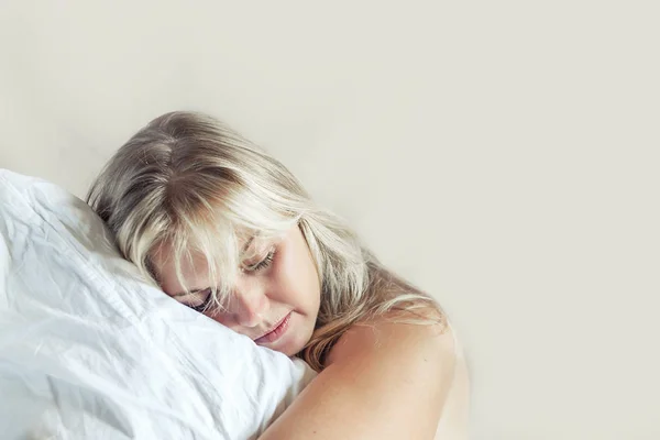Menina loira bonita acorda na cama . — Fotografia de Stock