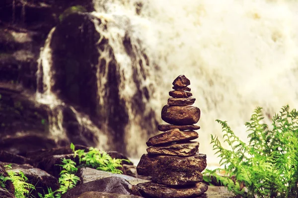 Taş piramit yakınındaki bir tropik şelale. 