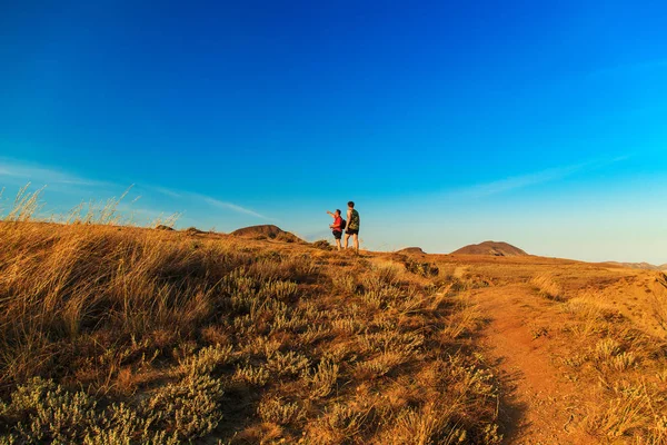 Tepeler arasında iki turist yürüyüş.