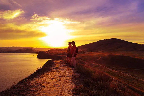 Two tourists walk across the hills. — Stock Photo, Image