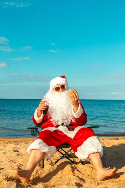 Noel Baba sahilde bir hamburger yemek. 